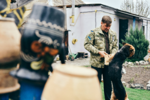 Андрей Микитенко играет с собакой в своем доме в селе Новое Пекельное, Харьковской области, 27 апреля. Фото Kiev Post (Олег Петрасюк).