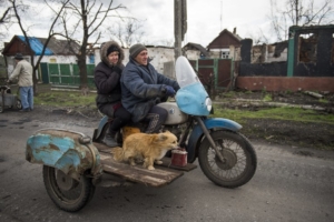 Семейная пара и их собака едут на мотоцикле с коляской в селе Никишино 21 апреля 2015 года. Никишино находится на территории, подконтрольной пророссийским сепаратистам. Фото AFP/Scanpix/Leta