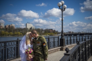  Участник вооруженных формирований самопровозглашенной республики с позывным Юнга целуется со своей невестой на мосту через реку Кальмиус в Донецке в день свадьбы 22 апреля 2015 года. Фото AFP/Scanpix/Leta
