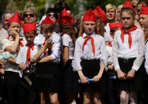 На этом фото, снятом 26 мая 2016 года в Донецке, дети в красных пилотках и галстуках, напоминающие советских пионеров, принимают участие в собрании молодежного движения “Патриот” в окрестностях Донецка. Фото AFP/Scanpix/Leta